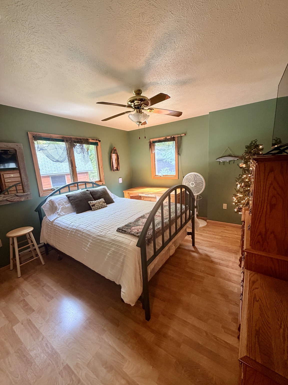 Bedroom 1, wide view of the queen bed and two windows
