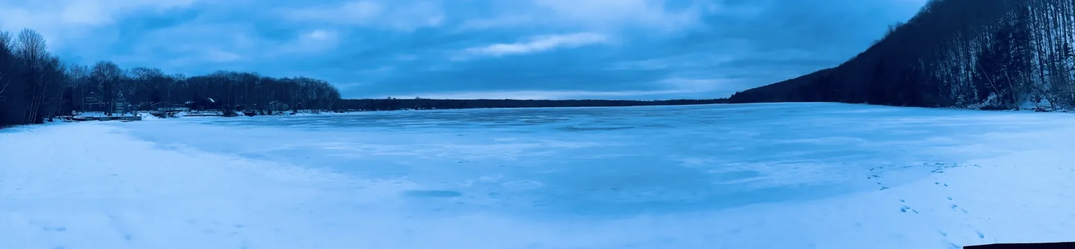 Wide snowy lake and forest shoreline